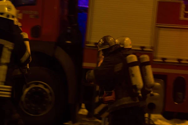 Bomberos en el trabajo. extinguiendo el agua de fuego en la noche de invierno. torre de bomberos, manguera de incendios. Kiev, 20 de enero de 2018 — Foto de Stock