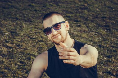 Stadyumdaki idmandan sonra spor giyimli genç adam çimlerin üzerinde dinleniyor. eğitimden sonra iyileşme