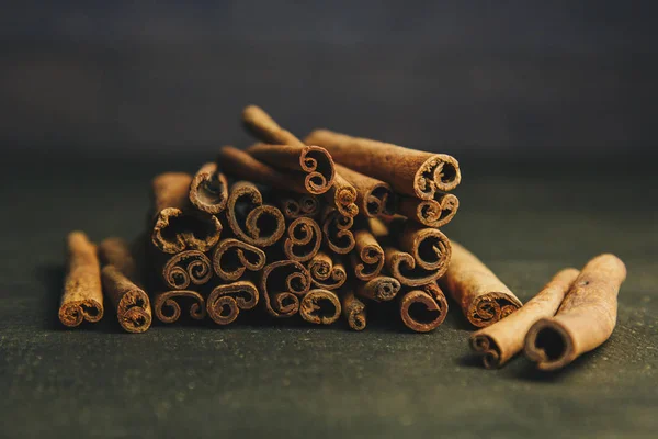 Un montón de palos enteros de canela fragante en una mesa rural de madera. espacio de copia. composición de condimentos y especias aromáticas de saborización de diapositivas. Primer plano. vista frontal —  Fotos de Stock