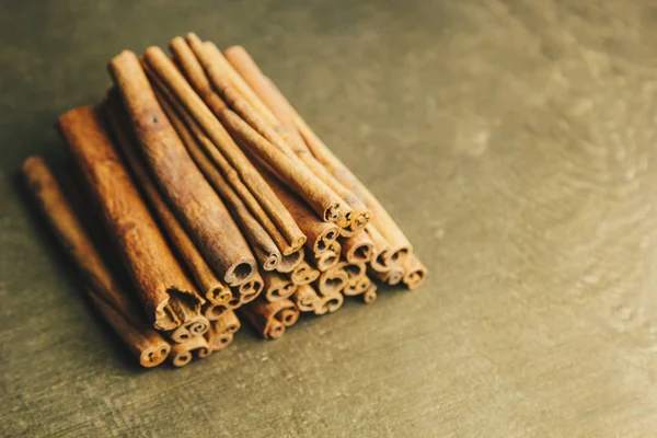 Un montón de palos enteros de canela fragante en una mesa rural de madera. espacio de copia. composición de condimentos y especias aromáticas de saborización de diapositivas. Primer plano. vista superior — Foto de Stock