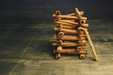 ahşap bir kırsal masada kokulu tarçın bütün sopakule. copyspace. baharat ve slayt aromatik baharat tatlandırıcı kompozisyon. Close. yan görünüm, makro