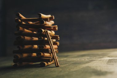 ahşap bir kırsal masada kokulu tarçın bütün sopakule. copyspace. baharat ve slayt aromatik baharat tatlandırıcı kompozisyon. Close. yan görünüm, makro