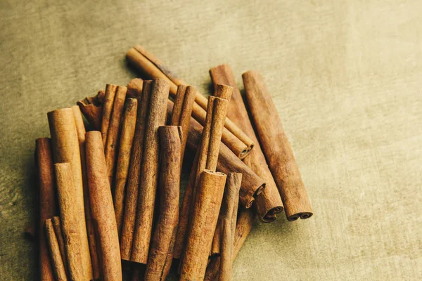 Un montón de palos enteros de canela fragante en una mesa rural de madera. espacio de copia. composición de condimentos y especias aromáticas de saborización de diapositivas. Primer plano. vista superior — Foto de Stock