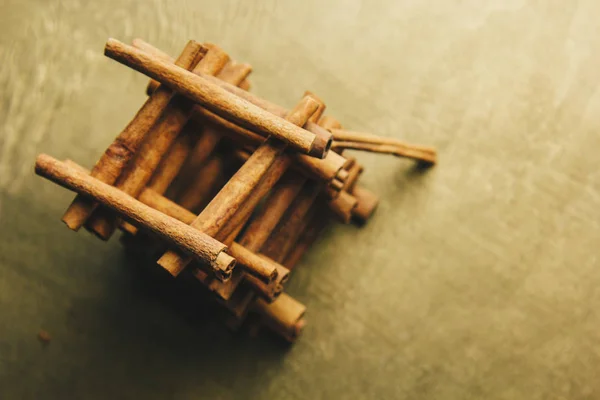 Torre de palos enteros de canela fragante sobre una mesa rural de madera. espacio de copia. composición de condimentos y especias aromáticas de saborización de diapositivas. Primer plano. vista superior, macro — Foto de Stock