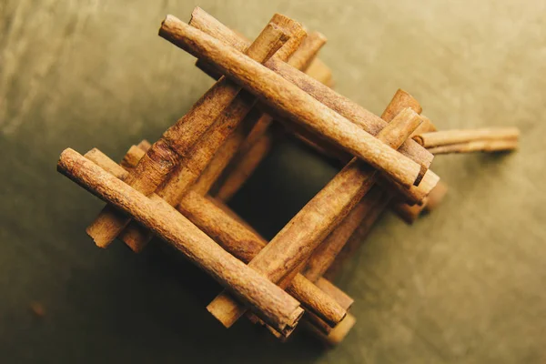 Torre de palos enteros de canela fragante sobre una mesa rural de madera. espacio de copia. composición de condimentos y especias aromáticas de saborización de diapositivas. Primer plano. vista superior, macro — Foto de Stock