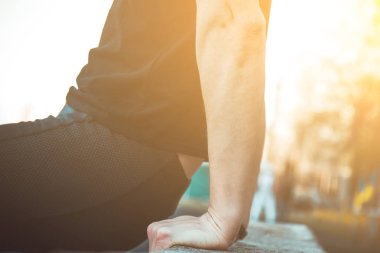 Siyah elbiseli genç bir adam açık havada yakın egzersiz. spor alanında fitness sporcusu. mermi ile eğitim. yaz için vücut hazırlığı ısınmak