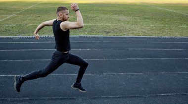 Beyaz bir erkek sprint başlangıcı yapıyor. kauçuk yolda çalışıyor. Spor üniformalı atletizm koşucusu. enerjik fiziksel aktiviteler. açık hava egzersiz, sağlıklı yaşam tarzı. çalışan atlar