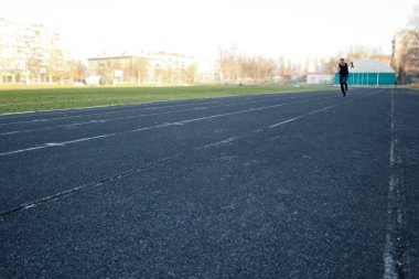 Beyaz bir erkek sprint başlangıcı yapıyor. kauçuk yolda çalışıyor. Spor üniformalı atletizm koşucusu. enerjik fiziksel aktiviteler. açık hava egzersiz, sağlıklı yaşam tarzı