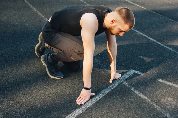 one man on the start line awaits the start of the sprint. stadium, rubber track. athletics competitions. Track and field runner in sport uniform. athlete, top view