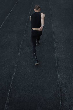 kafkas adam bir sprint başlangıç yapıyor. bir parça üzerinde stadyum üzerinde çalışan. Spor üniformalı atletizm koşucusu. enerjik fiziksel aktiviteler. açık hava egzersiz, sağlıklı yaşam tarzı. dikey üst görünüm