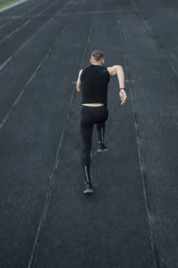 kafkas adam bir sprint başlangıç yapıyor. bir parça üzerinde stadyum üzerinde çalışan. Spor üniformalı atletizm koşucusu. enerjik fiziksel aktiviteler. açık hava egzersiz, sağlıklı yaşam tarzı. dikey üst görünüm