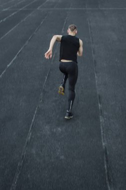 kafkas adam bir sprint başlangıç yapıyor. bir parça üzerinde stadyum üzerinde çalışan. Spor üniformalı atletizm koşucusu. enerjik fiziksel aktiviteler. açık hava egzersiz, sağlıklı yaşam tarzı. dikey üst görünüm