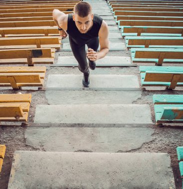 Kafkas adam merdivenlerde koşarken antrenman lar. Atletizm koşucusu spor üniforması eğitim açık. atlet, üst görünümü. adım egzersizleri. Dikey