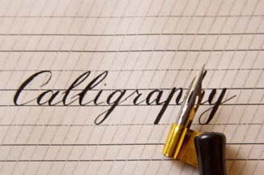 Kaligrafi beyaz kağıt bir sayfaya çizgili mürekkep kalemle yazılır. Kırtasiye üst görüntüyü kapatın. Heceleme dersleri ve kaligrafi alıştırmaları. Şablon, düzen, arka plan. makro