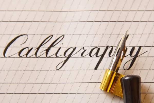 Kaligrafi beyaz kağıt bir sayfaya çizgili mürekkep kalemle yazılır. Kırtasiye üst görüntüyü kapatın. Heceleme dersleri ve kaligrafi alıştırmaları. Şablon, düzen, arka plan. makro