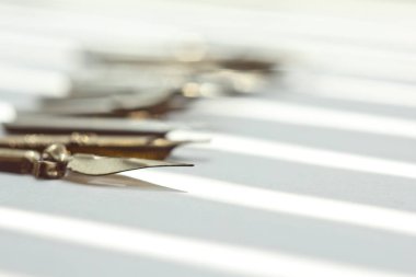 güneş ışınları beyaz bir arka plan üzerinde mürekkep kalem için metal ipuçları. beyaz masada kırtasiye üst görünümü kapatın. yazım dersleri ve kaligrafi egzersizleri. Şablon, düzen, arka plan. Makro