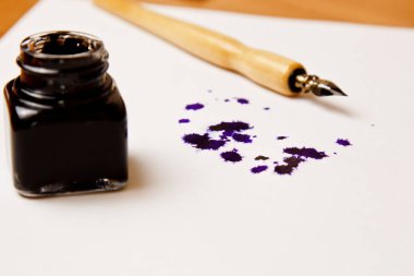 mürekkep le birlikte beyaz bir kağıt tabaka üzerinde mürekkepli kalemle çizilmiş mürekkep lekesi. blot ve kırtasiye üst görünümü kadar kapatın. yazım dersleri ve kaligrafi egzersizleri. Şablon, düzen, arka plan. Makro