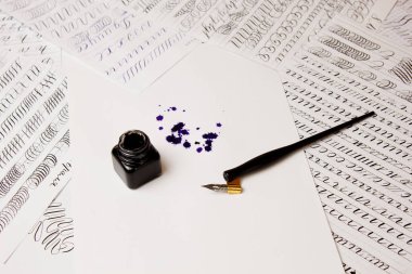 mürekkep le birlikte beyaz bir kağıt tabaka üzerinde mürekkepli kalemle çizilmiş mürekkep lekesi. blot ve kırtasiye üst görünümü kadar kapatın. yazım dersleri ve kaligrafi egzersizleri. Şablon, düzen, arka plan. Makro