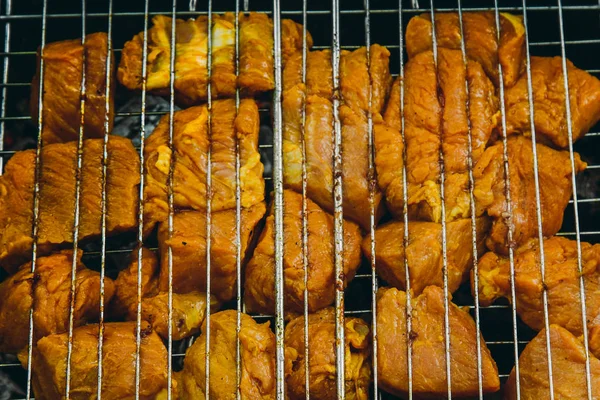 Würfel aus eingelegtem Fleisch in einem Grillrost am Kohlenbecken braten. Dönerspieße auf Glutnestern grillen. gegrilltes Picknick in der Natur. Ansicht von oben aus nächster Nähe — Stockfoto