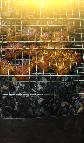 Würfel aus eingelegtem Fleisch in einem Grillrost am Kohlenbecken braten. Dönerspieße auf Glutnestern grillen. gegrilltes Picknick in der Natur. Ansicht von oben aus nächster Nähe — Stockfoto