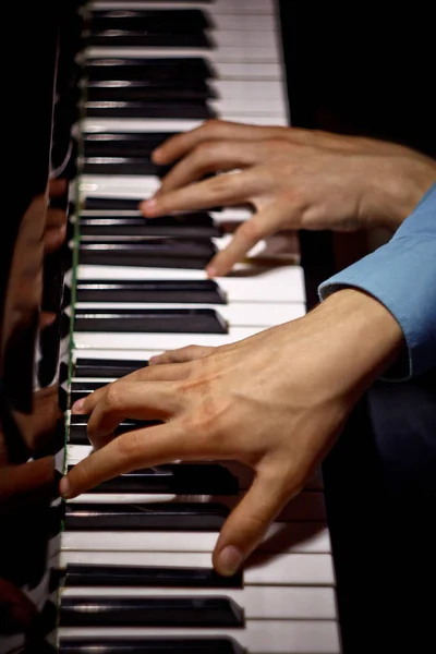 피아노에 두 남성 손. 손바닥은 가로 로 키에 누워 음악 학교에서 키보드 악기를 재생할 수 있습니다. 학생은 놀이를 배운다. 손 피아니스트. 검은 색 어두운 배경. 상단 보기. 수직 — 스톡 사진