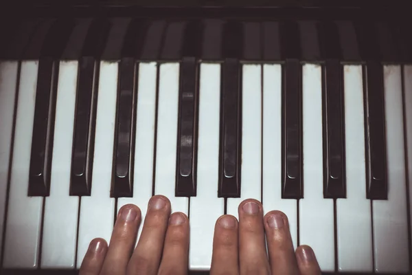 Dos manos masculinas en el piano. las palmas yacen en las teclas y tocan el instrumento de teclado en la escuela de música. estudiante aprende a jugar. manos pianista. fondo negro oscuro. vista superior — Foto de Stock