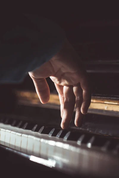피아노에 한 남성 손. 손바닥은 건반에 놓여 있으며 음악 학교에서 키보드 악기를 연주합니다. 학생은 놀이를 배운다. 손 피아니스트. 검은 색 어두운 배경. 수직 — 스톡 사진