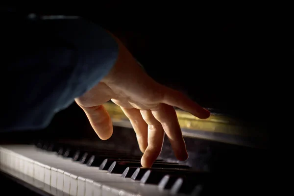 Egy férfi kezét a zongorán. A tenyér fekszik-on kulcsok és játszik a billentyűzet eszköz-ban zene iskola. tanuló megtanulja a játékot. kéz zongoraművész. fekete-sötét háttér — Stock Fotó