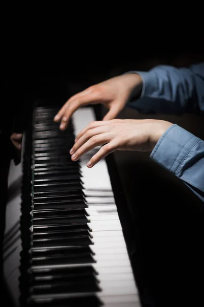 Deux mains masculines sur le piano. palms se trouvent sur les touches et jouent de l'instrument à clavier dans l'école de musique. élève apprend à jouer. pianiste des mains. fond noir foncé. vertical — Photo
