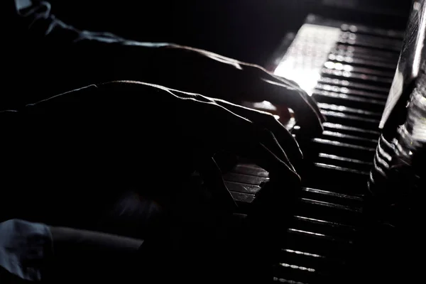 Due mani maschili al pianoforte. palme si trovano sui tasti e suonare lo strumento a tastiera nella scuola di musica. studente impara a giocare. pianista mani. nero sfondo scuro — Foto Stock