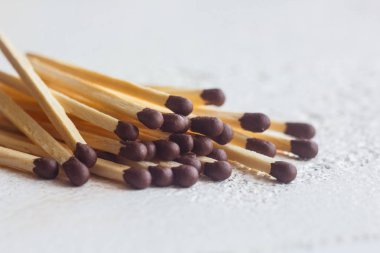 beyaz bir masaya yakın bir kibrit yığını. Bulanık arka planda makro yangın ateşleyici