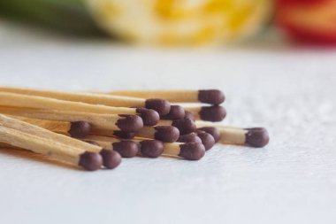 beyaz bir masaya yakın bir kibrit yığını. Bulanık arka planda makro yangın ateşleyici