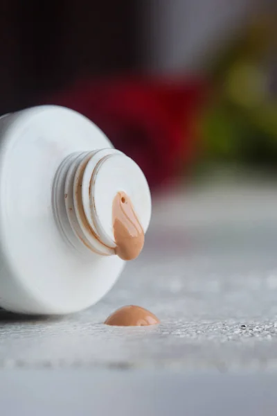 plastic mouth tube with cream and open lid close-up on a white table. cosmetics for body care close-up on a blurred background. vertical