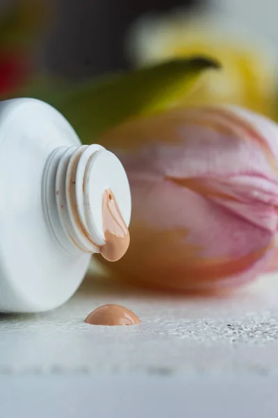 plastic mouth tube with cream and open lid close-up on a white table. cosmetics for body care close-up on a blurred background. vertical