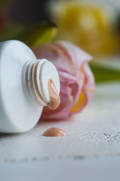 plastic mouth tube with cream and open lid close-up on a white table. cosmetics for body care close-up on a blurred background. vertical