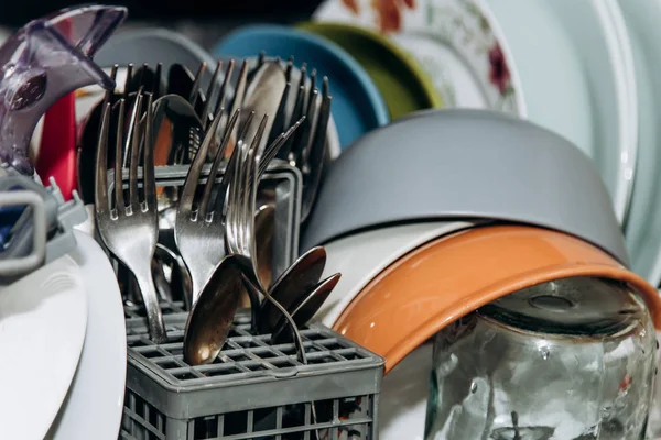 Offene Geschirrspülmaschine in Großaufnahme verstopft mit sauber gewaschenem Geschirr. Nahaufnahme von trockenem Besteck. Löffelgabeln vorhanden. Tassen, Teller vorhanden. Haushaltsgeräte in der Küche — Stockfoto