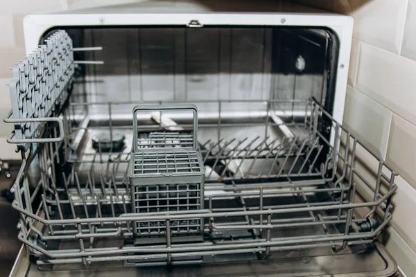 Esvaziar a máquina de lavar louça aberta fechar. compartimento de talheres close-up. eletrodomésticos na cozinha macro — Fotografia de Stock