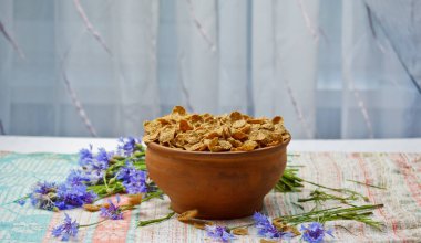 Bir seramik kase closeup üst görünümünde Şekermısır gevreği. mavi çiçekler closeup ile masaya dağılmış hafif kahvaltı. gıda fast cooking. sağlıklı gıda, diyet