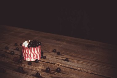 koyu bir arka plan üzerinde rustik ahşap masada kiraz meyveile şenlikli pasta. kopyalama alanını kapatın. tatlı tartlet üzerinde vintage desen. doğum günü tatili