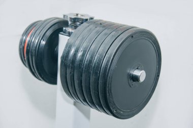 Ağır manuel metal halter beyaz bir arka plan üzerinde spor salonu yakın çekim raf üzerinde duruyor. eğitim araçları
