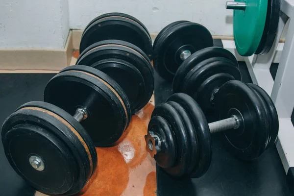 Hand metalen dumbbells liggen op de vloer in de sportschool close-up. TRAININGSHULPMIDDELEN — Stockfoto