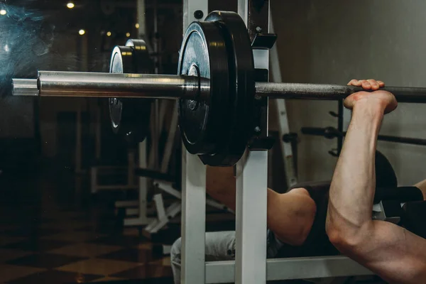 Sportler mit großen Händen, die eine Langhantelstange im Trainingszentrum halten. Trainingsgeräte in der Turnhalle aus nächster Nähe — Stockfoto