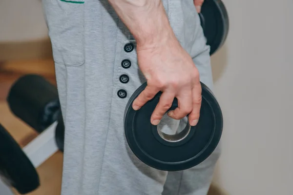 Atleta com grandes mãos segurando um disco de metal no centro de treinamento. ferramentas de treinamento no ginásio close-up — Fotografia de Stock