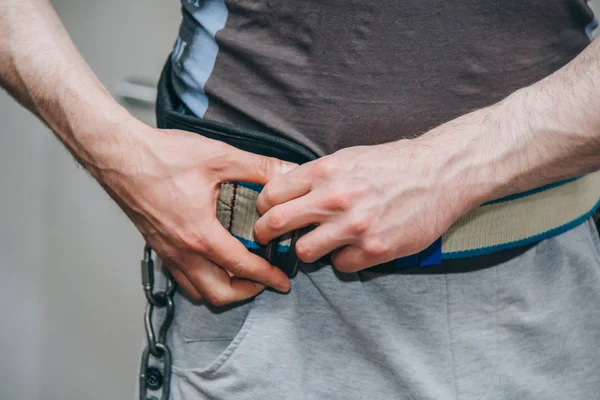 athlete wears a waist belt in the training center. training tools in the gym close-up
