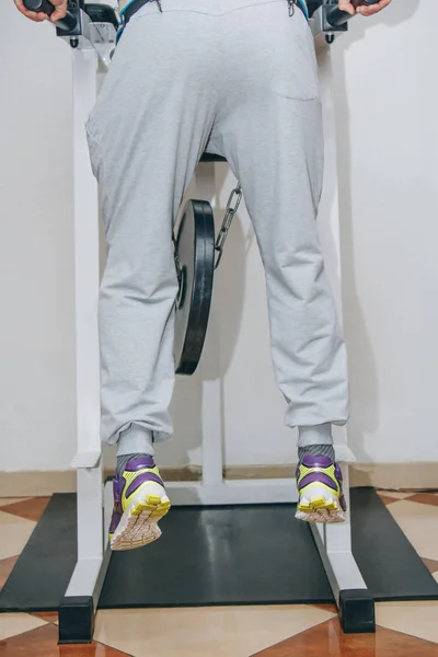 Atleta fazendo exercício com peso no cinto de cintura no centro de treinamento. ferramentas de treinamento no ginásio close-up — Fotografia de Stock