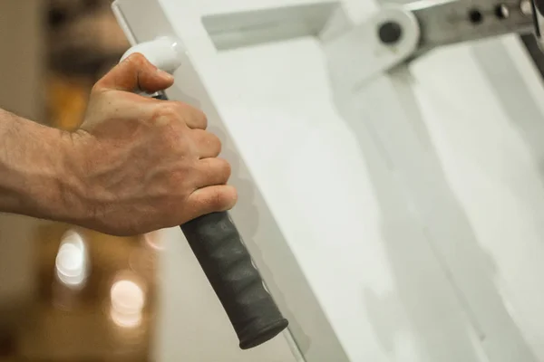 The athlete holds his hands on the hilt of the training machine in the training center. training tools in the gym close-up