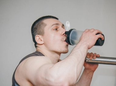 atlet eğitim merkezinde bir shaker su içiyor. spor salonunda egzersizler arasında dinlenme