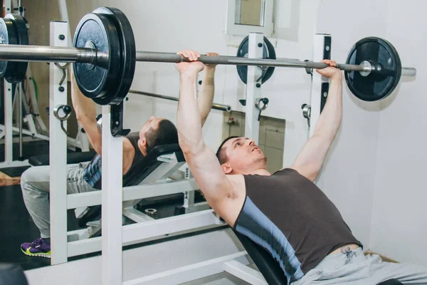 V centru výcviku sportovec třese svaly. Cvičte hrudní tisk. školicí nástroje v posilovně zblízka — Stock fotografie