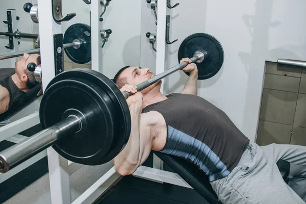 athlete shakes pectoral muscles in the center of training. exercise chest press. training tools in the gym close-up