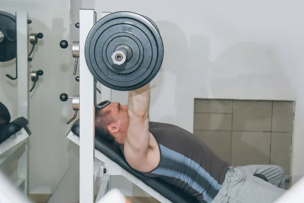 Sportler schüttelt Brustmuskeln im Zentrum des Trainings. Brustpresse üben. Trainingsgeräte in der Turnhalle aus nächster Nähe — Stockfoto